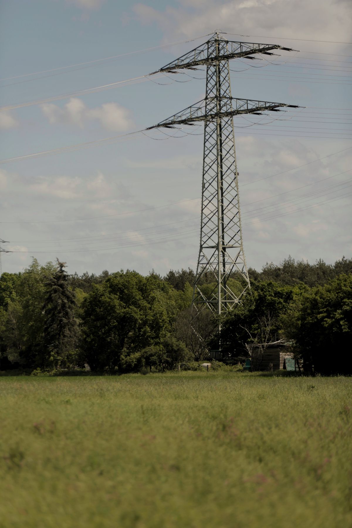 Double-circuit lattice transmission tower standing in farmland